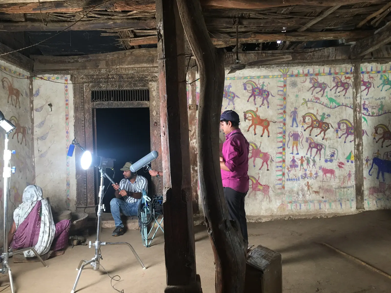 Sound recordist at work inside a house decorated with folk paintings